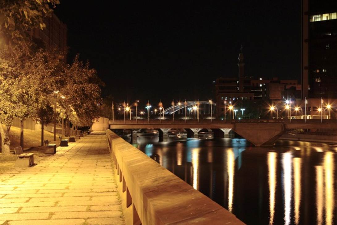 A walkway with lights on the side of the water

AI-generated content may be incorrect.